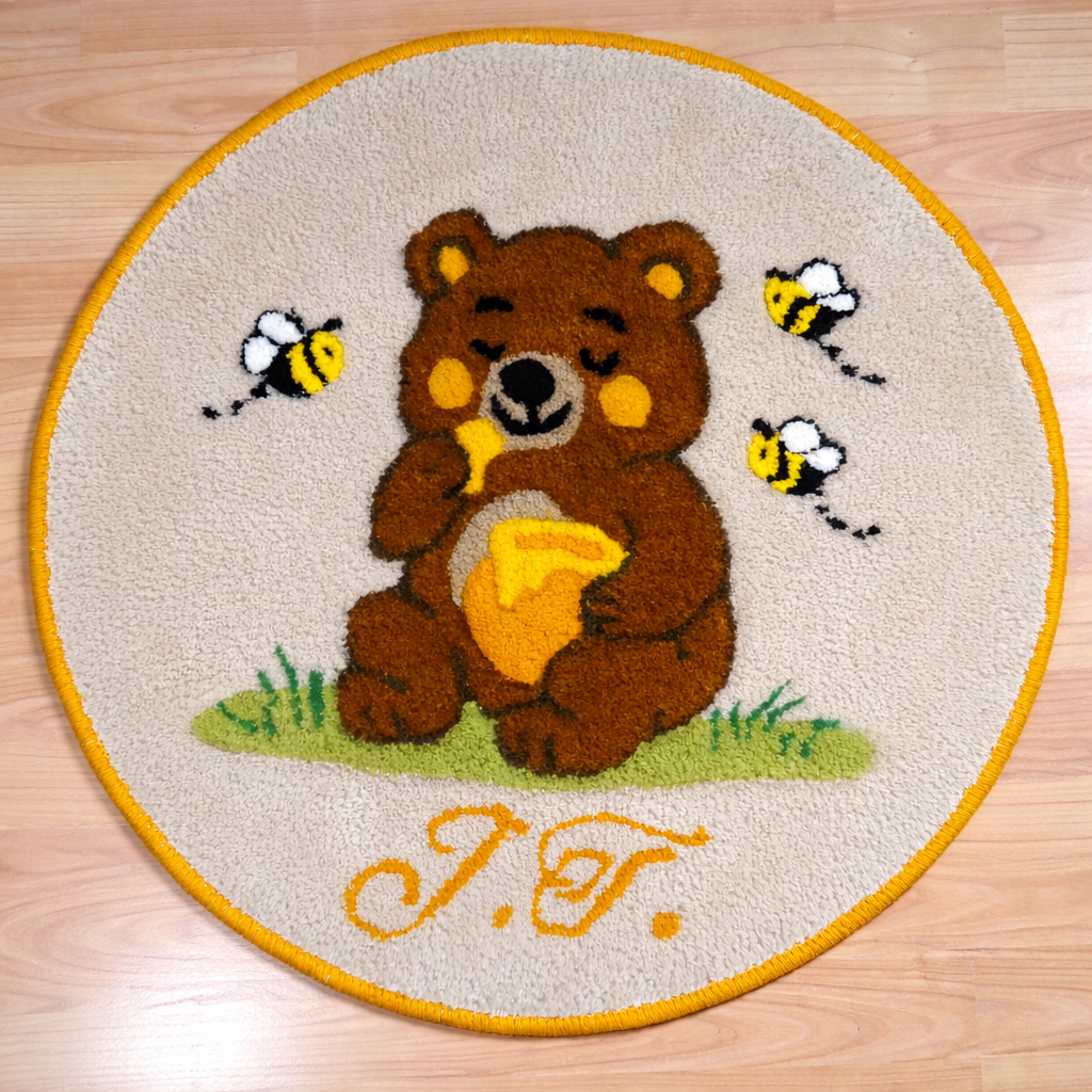 Round hand-tufted wool rug with a carved 3D teddy bear motif and personalized initials, made from 100% natural wool with a contrasting stitched border.