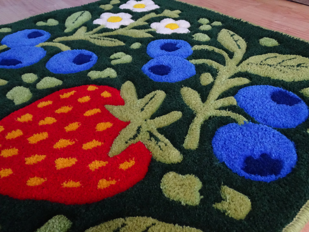 Close-up of a handmade children’s rug showing raised strawberry and blueberry details, carved 3D texture, made from 100% natural Baltic sheep wool