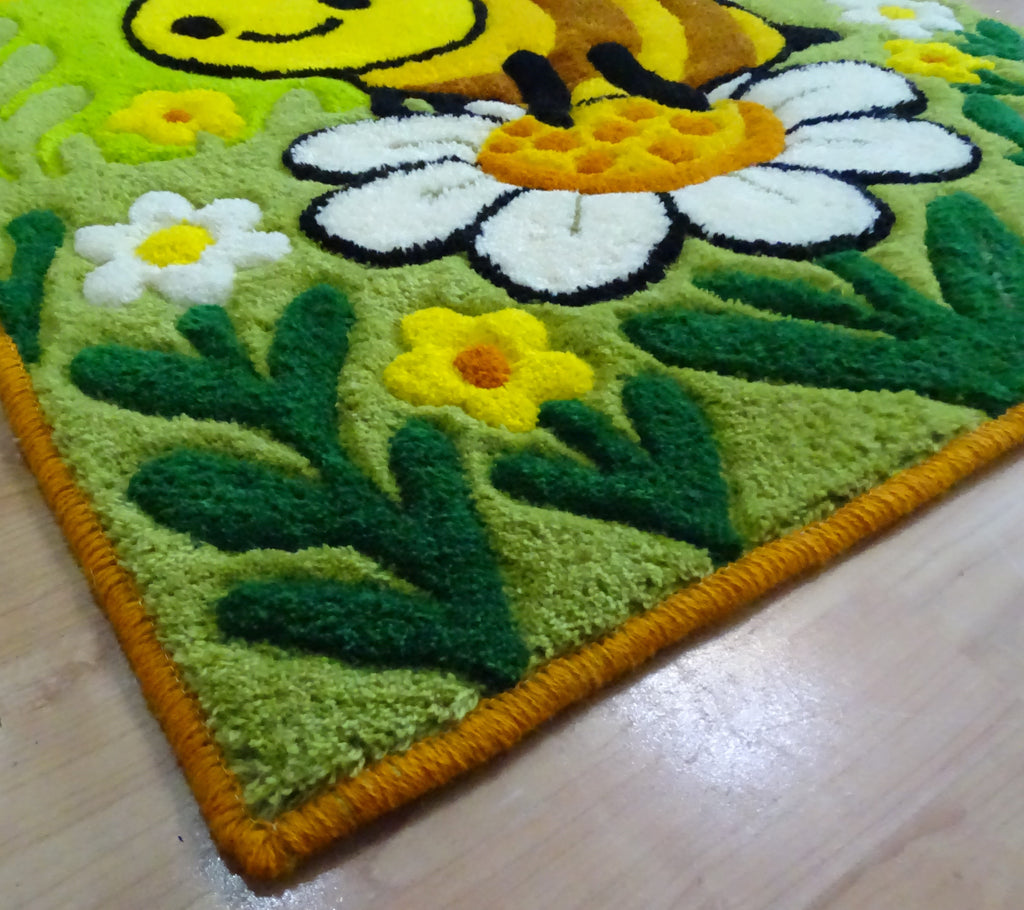 Nahaufnahme der 3D-geschnitzten Schrift auf personalisiertem Wollteppich mit Bienenmotiv, handgefertigt in Lettland.