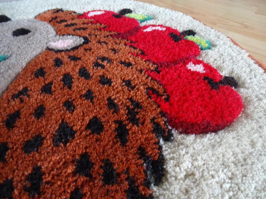 Detailaufnahme der handgetufteten Struktur aus 100 % Wolle mit plastischer Oberfläche, sorgfältig geschnittenen Konturen und natürlichen Farben.