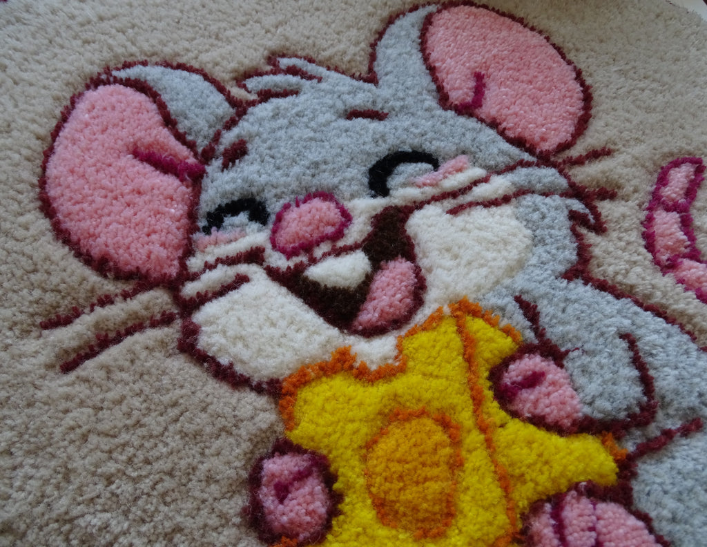 Close-up of hand-tufted wool rug texture showing dense, soft pile and carved detailing of the mouse design.