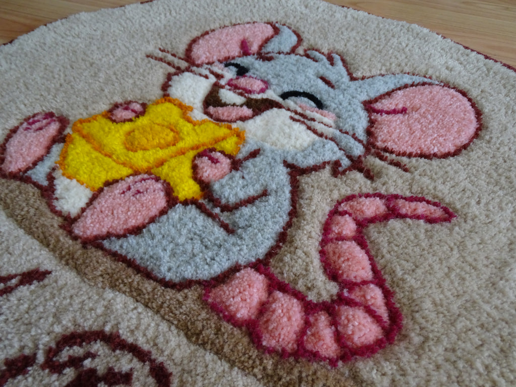 Close-up of hand-tufted wool rug texture showing dense, soft pile and carved detailing of the mouse design.