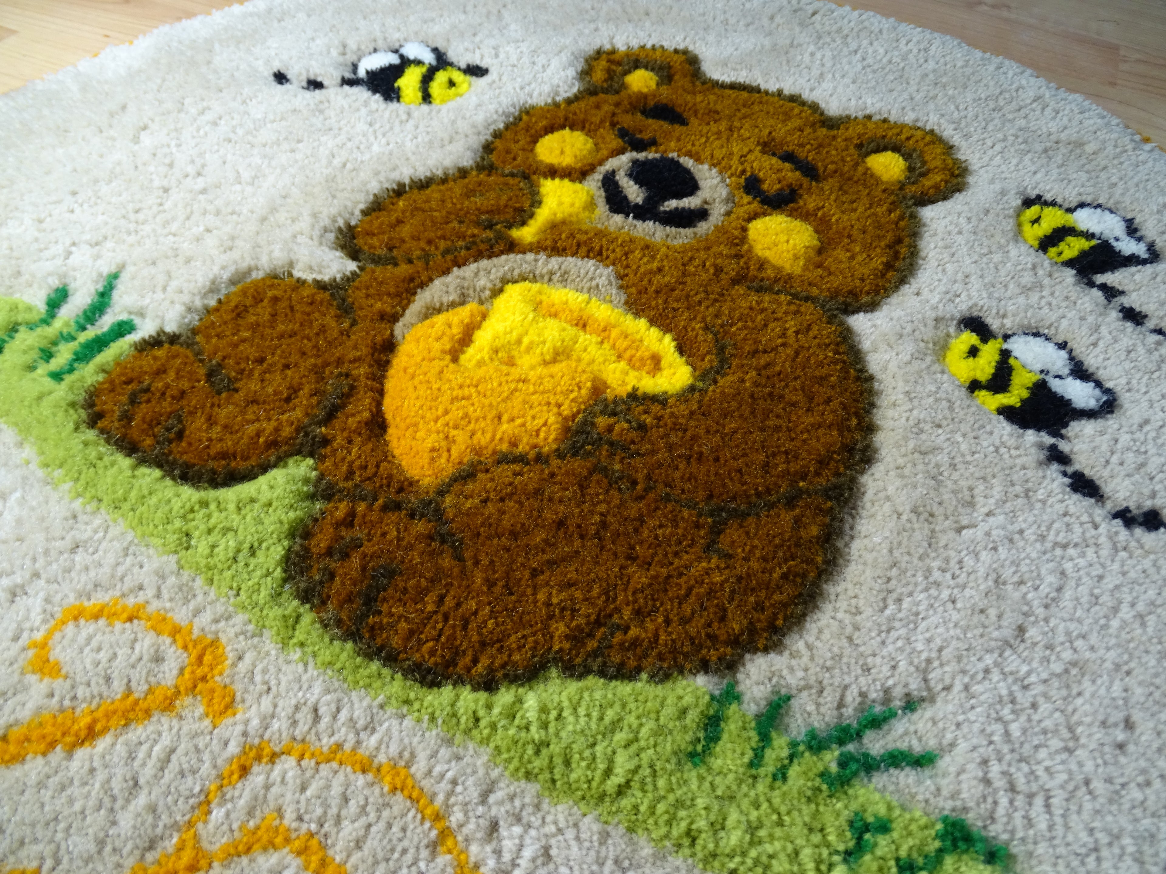 Round hand-tufted wool rug with a carved 3D teddy bear motif and personalized initials, made from 100% natural wool with a contrasting stitched border.