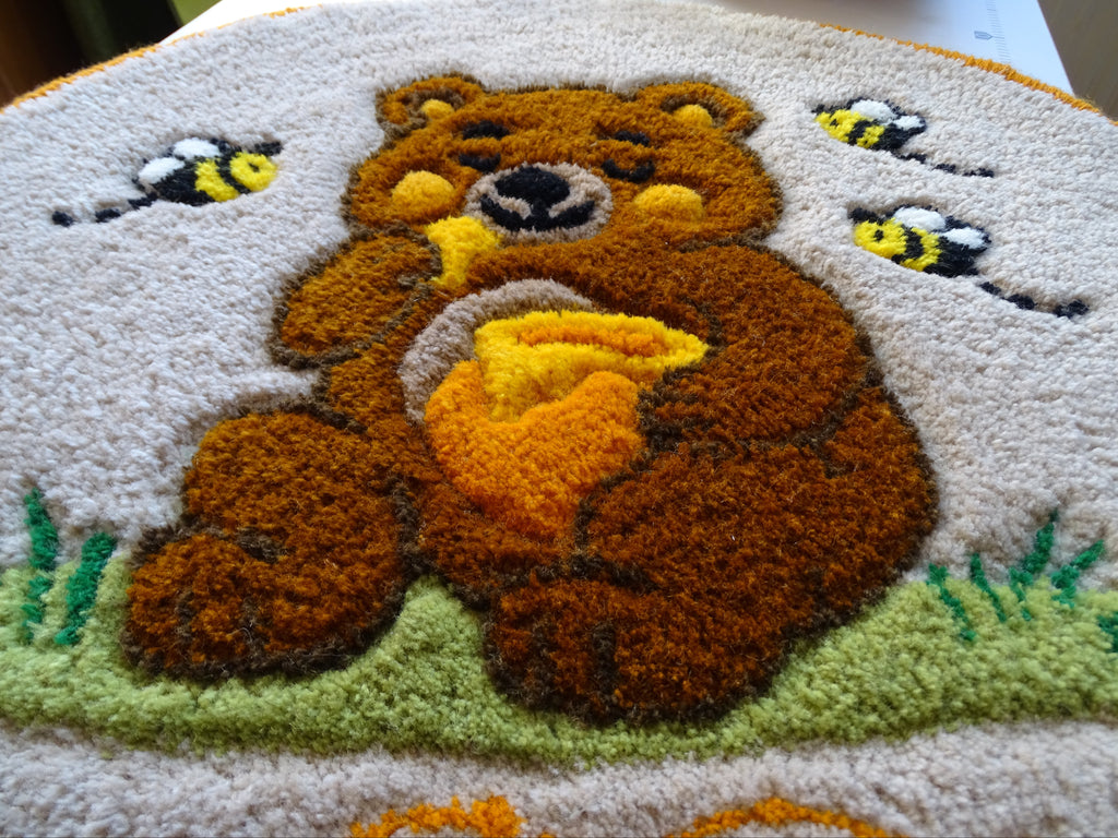 Round hand-tufted wool rug with a carved 3D teddy bear motif and personalized initials, made from 100% natural wool with a contrasting stitched border.