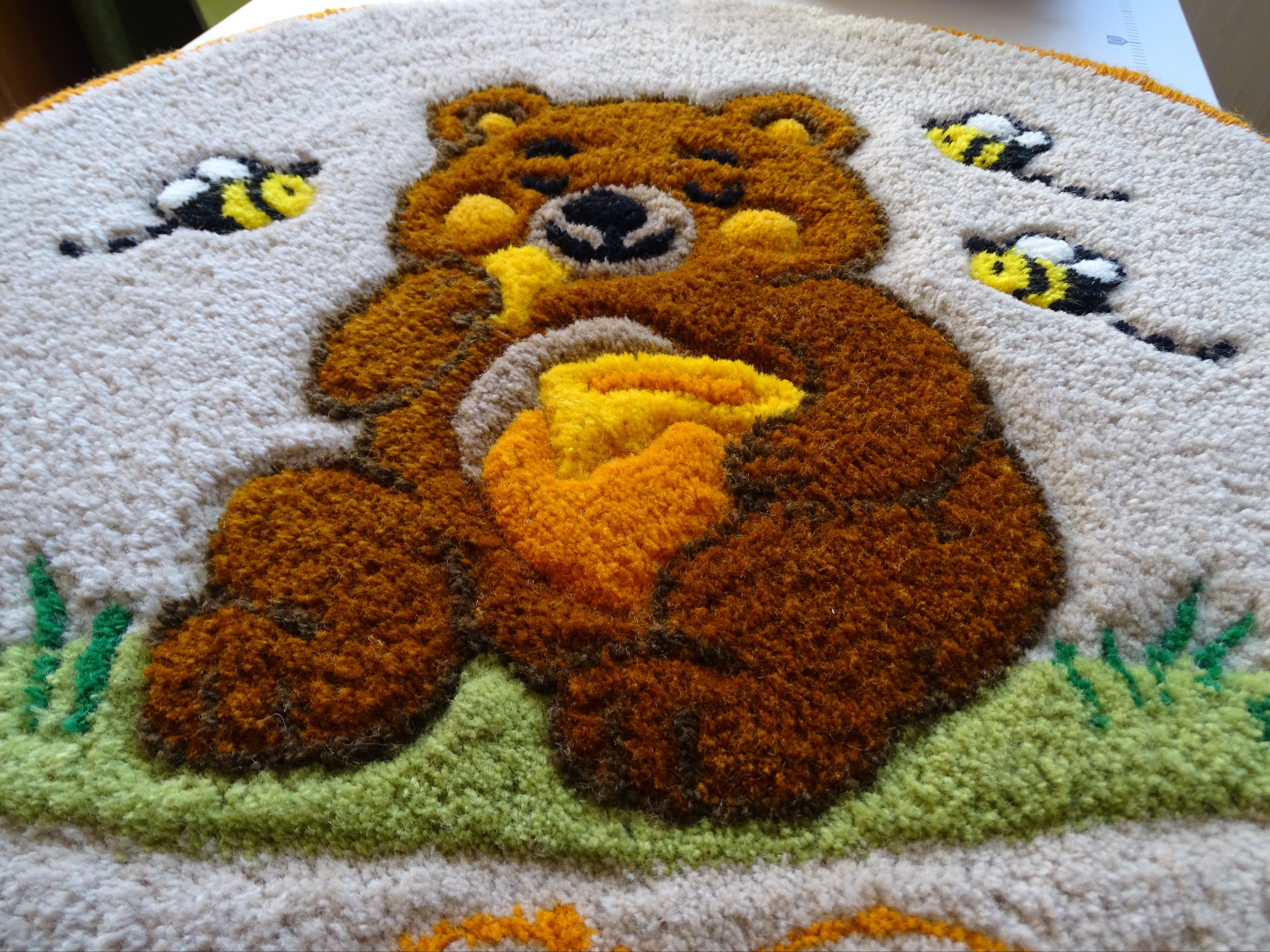 Round hand-tufted wool rug with a carved 3D teddy bear motif and personalized initials, made from 100% natural wool with a contrasting stitched border.