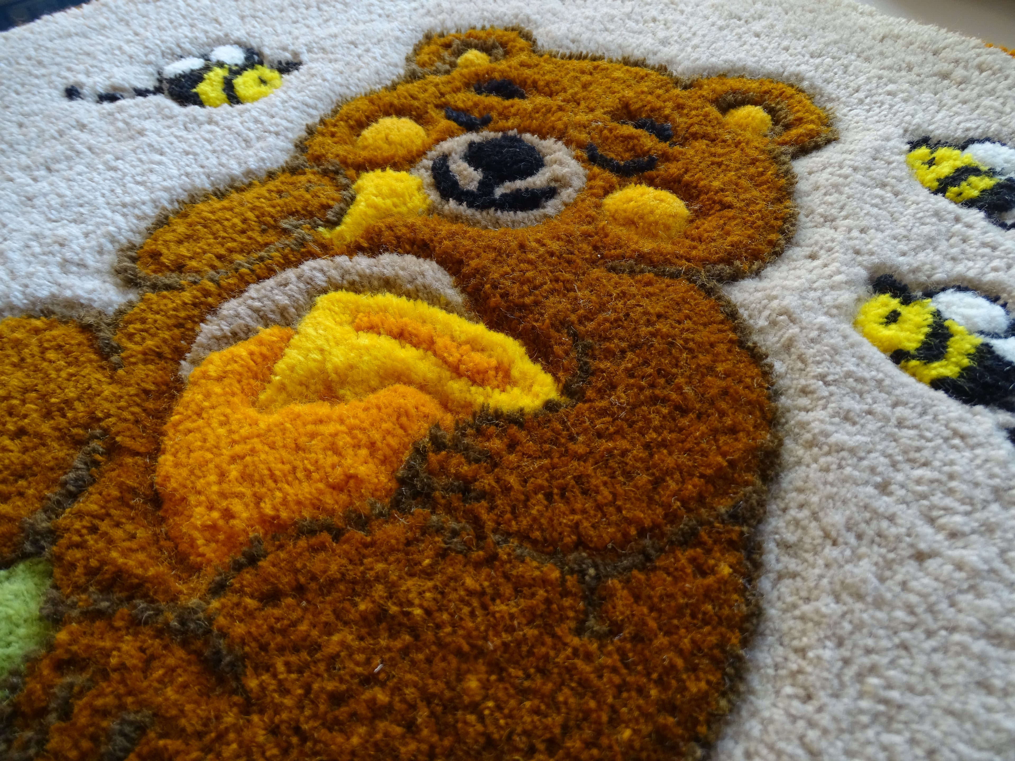 Round hand-tufted wool rug with a carved 3D teddy bear motif and personalized initials, made from 100% natural wool with a contrasting stitched border.