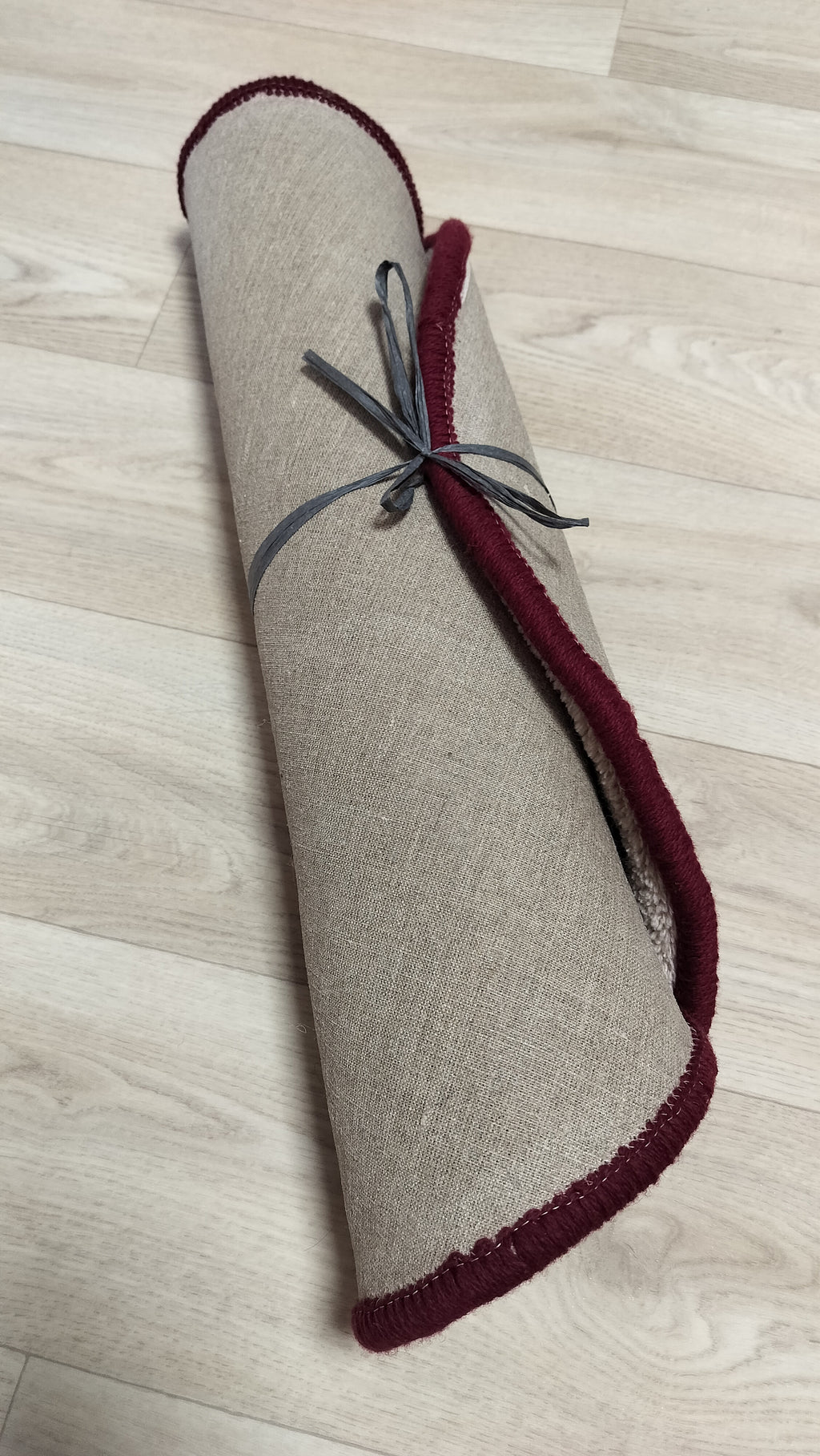 Backside of hand tufted wool rug showing natural latex anti slip backing and linen base